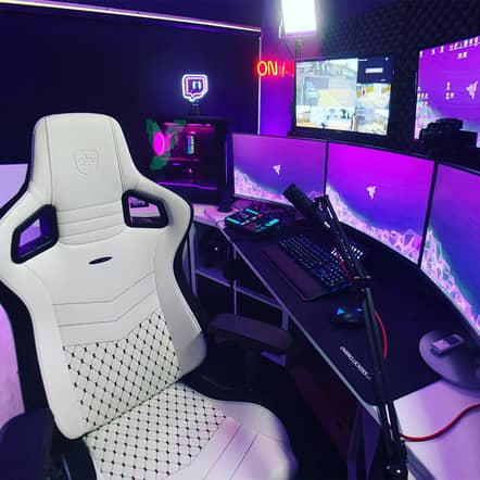 High-end gaming setup with a white EPIC SK Edition chair, triple-monitor display, and RGB-lit PC—showcasing the best chair for video gaming with a sleek design, ergonomic comfort, and pro-level support.